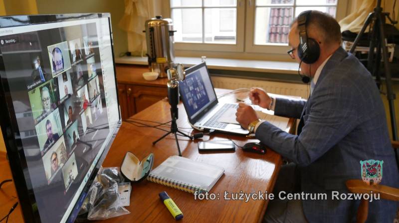 Zastępca przewodniczącego Rady Miasta Lubań siedzi przed komputerem podczas trwania zdalnych obrad Rady Miasta Lubań